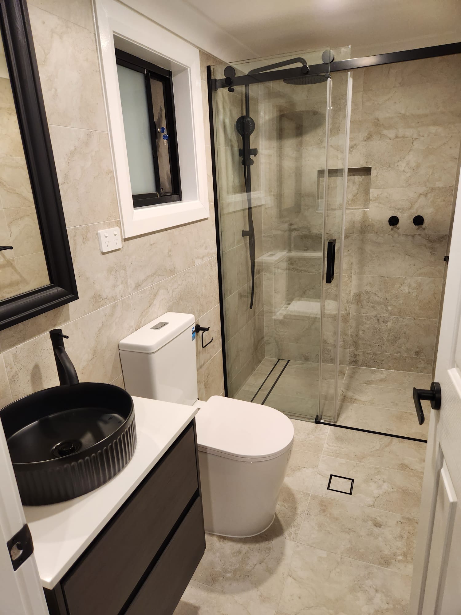 Sydney bathroom renovation with stone-look tiles, black fixtures and walk-in shower